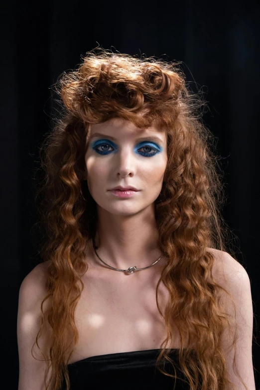 a young woman with long red hair and blue eyes