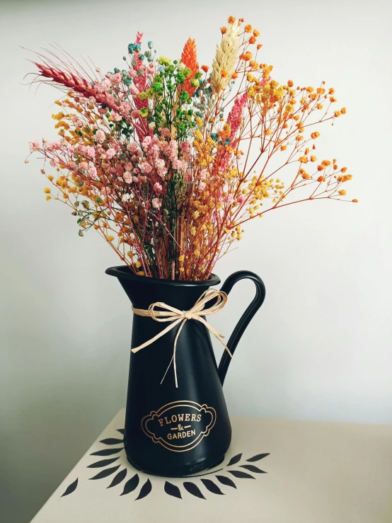 a black vase filled with a bouquet of flowers