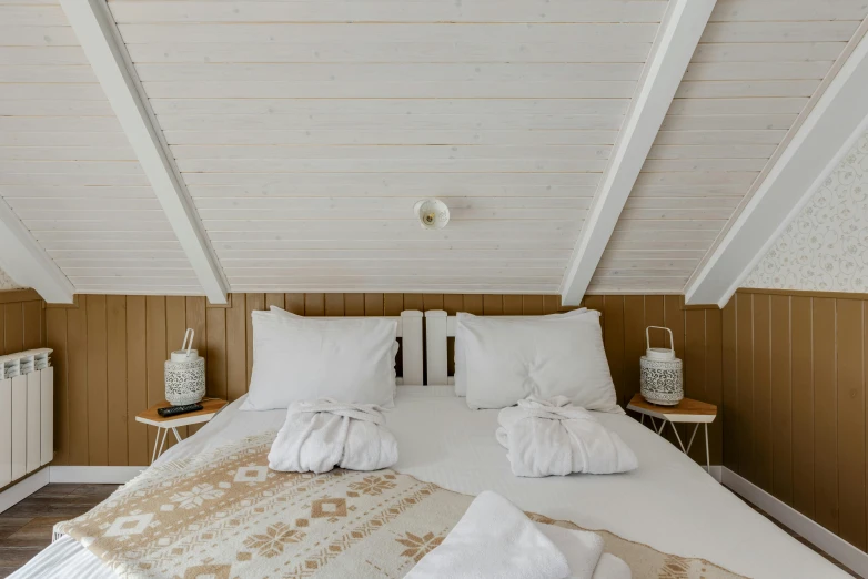 a bedroom with a bed and white sheets on top