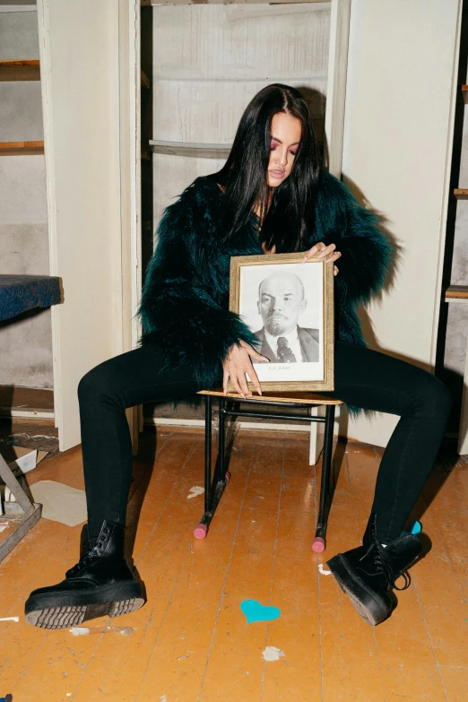 a person sitting in a chair and holding a framed picture