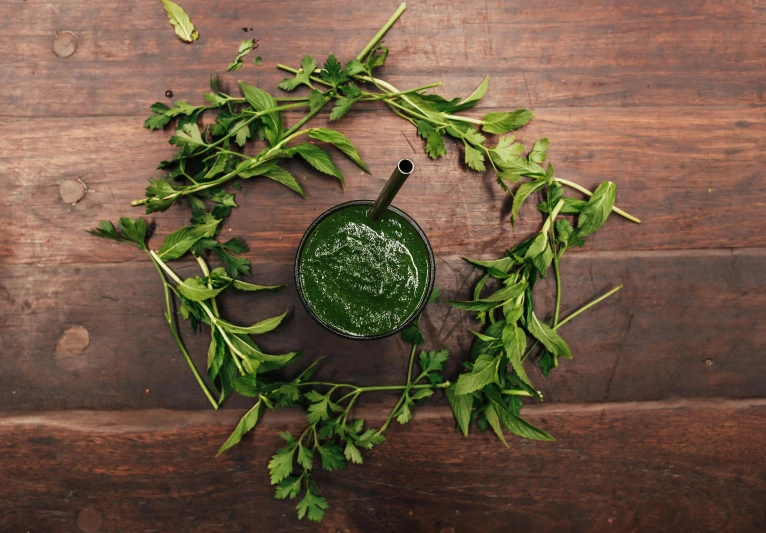 green leafy herbs on a wooden surface with leaves