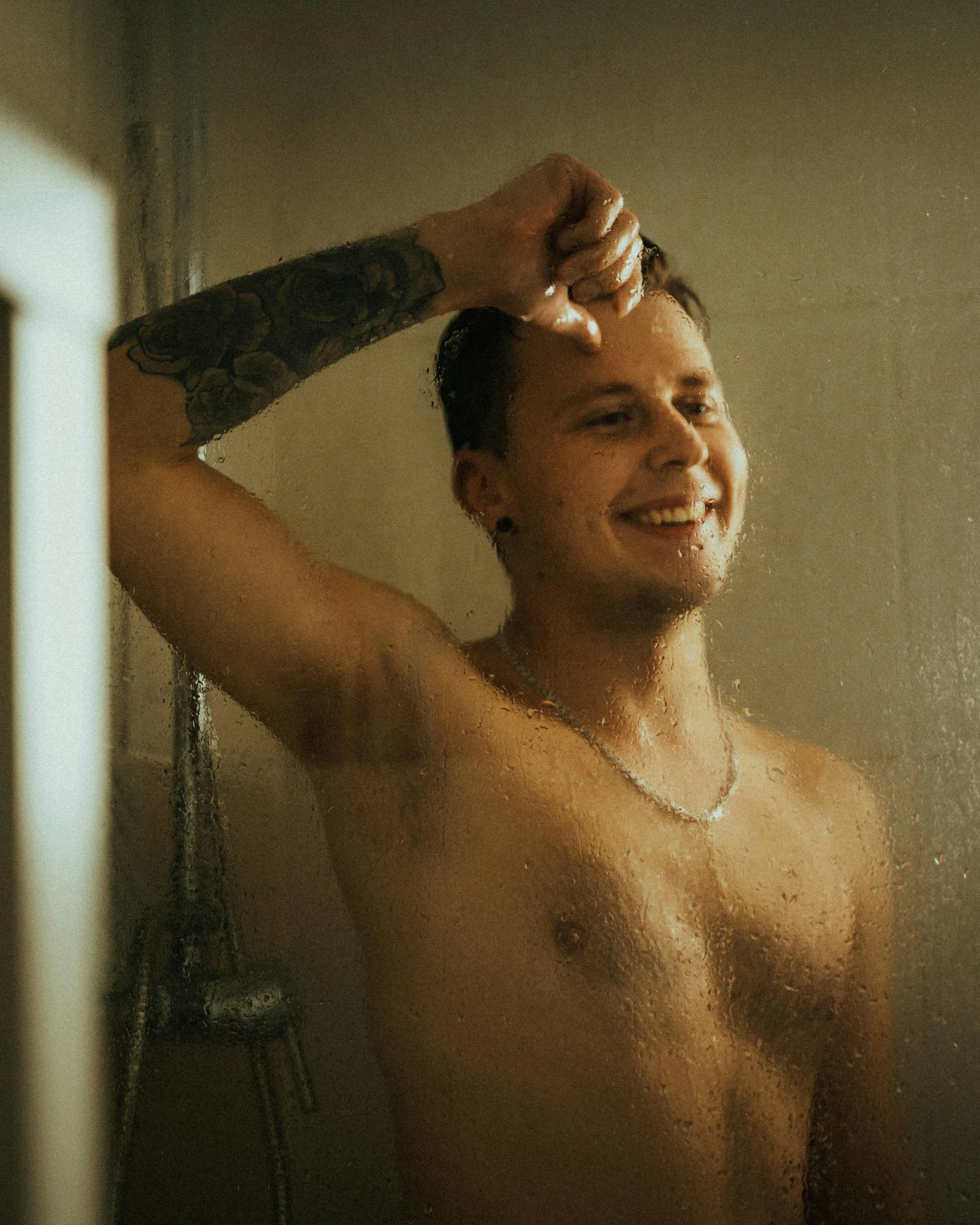 a man is smiling and brushing his hair