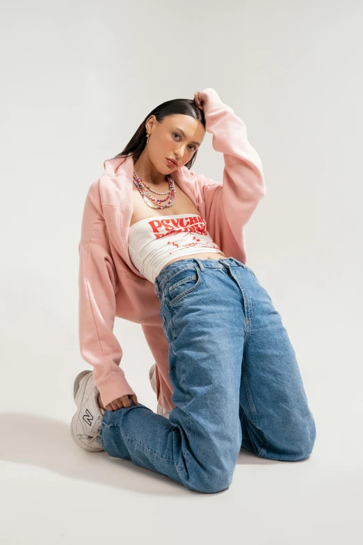 a woman in jeans and sweatshirt sitting on the floor