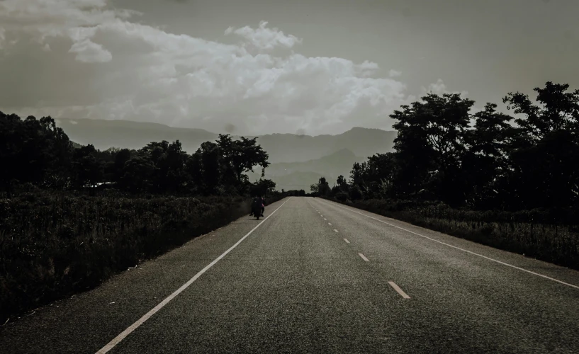 a motorcyclist travels down the middle of the road