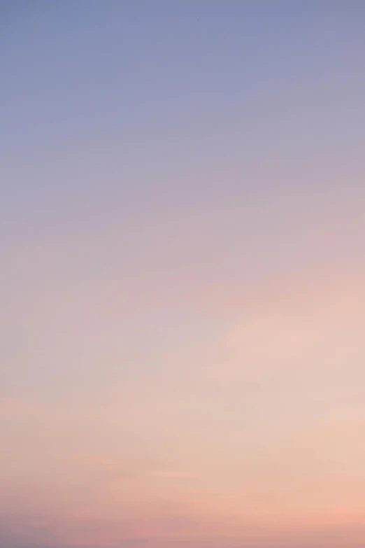 a red airplane flying through the air at sunset