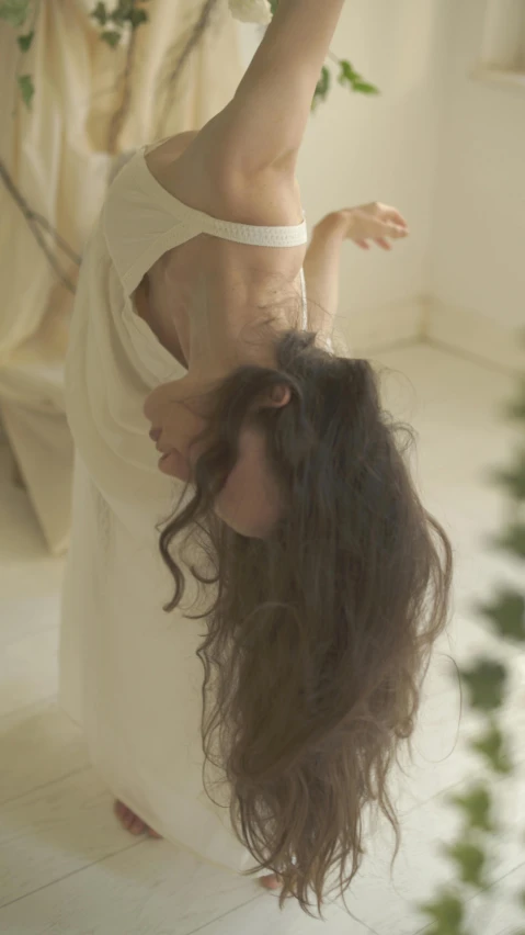 a woman in a white dress is upside down