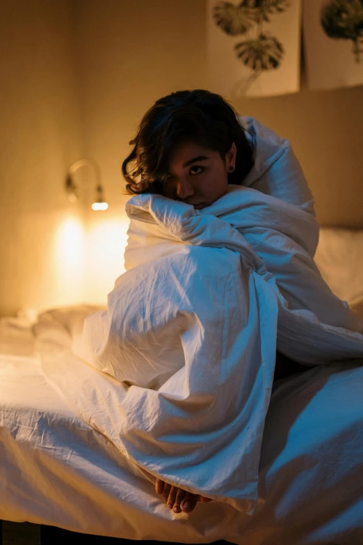 a woman wrapped up in blankets on her bed