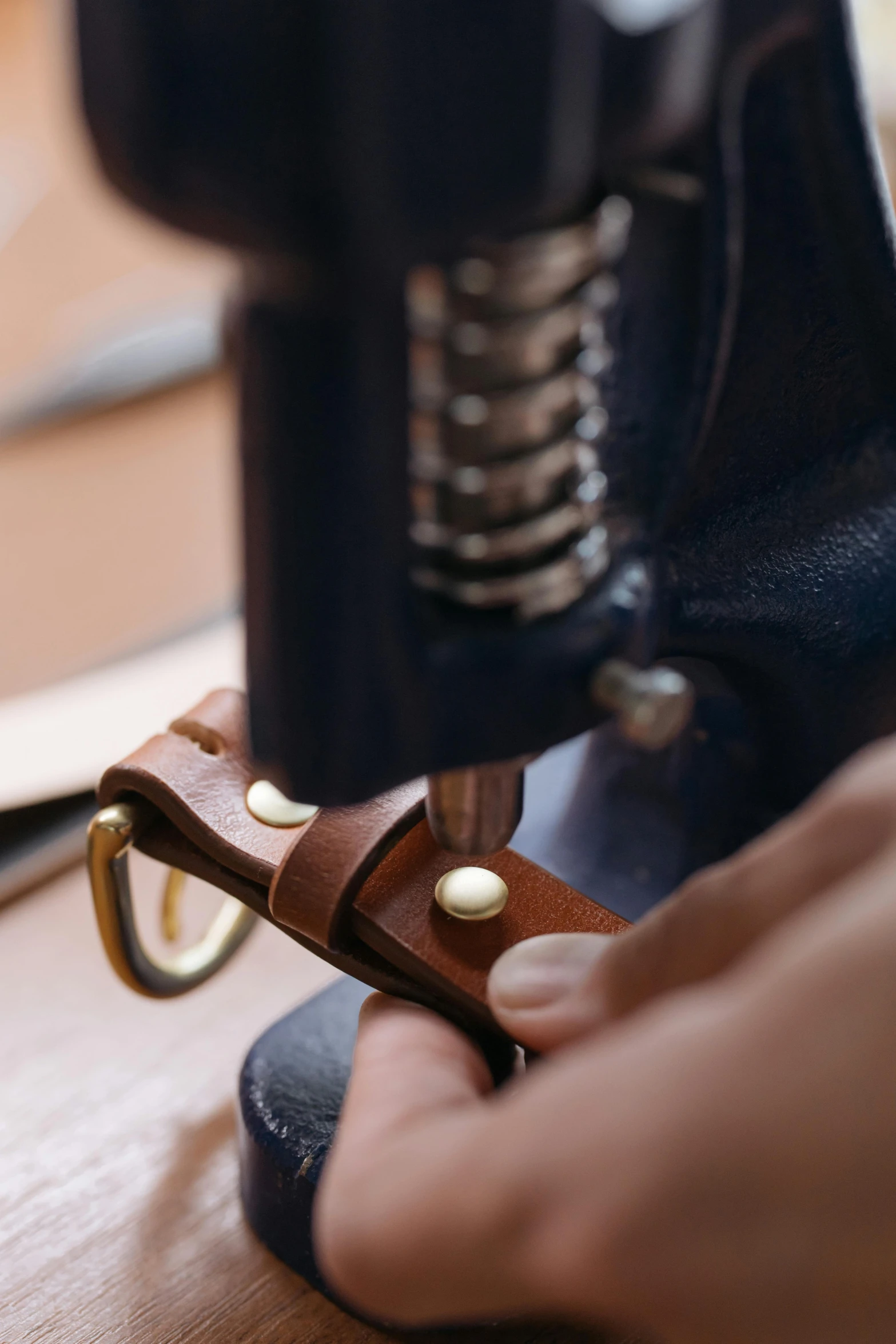 a person pulling the end of a leather strap on an object