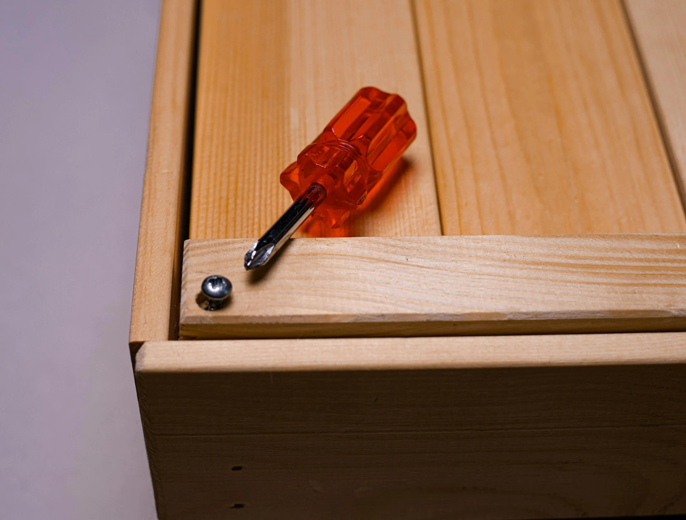 a pair of tools attached to the inside of an unfinished wooden drawer