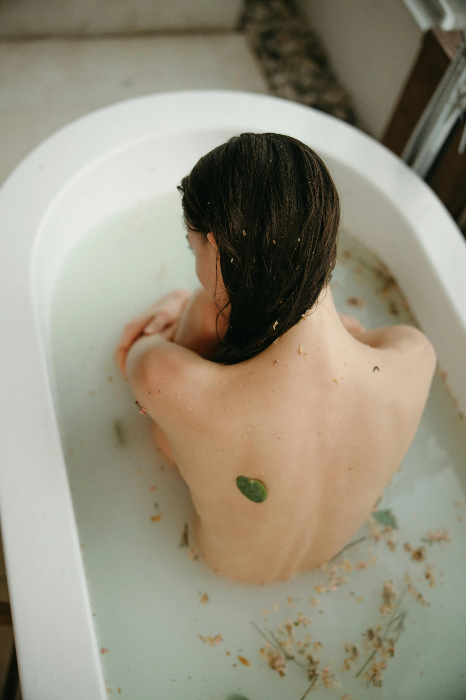 a woman sits in a bath tub filled with leaves