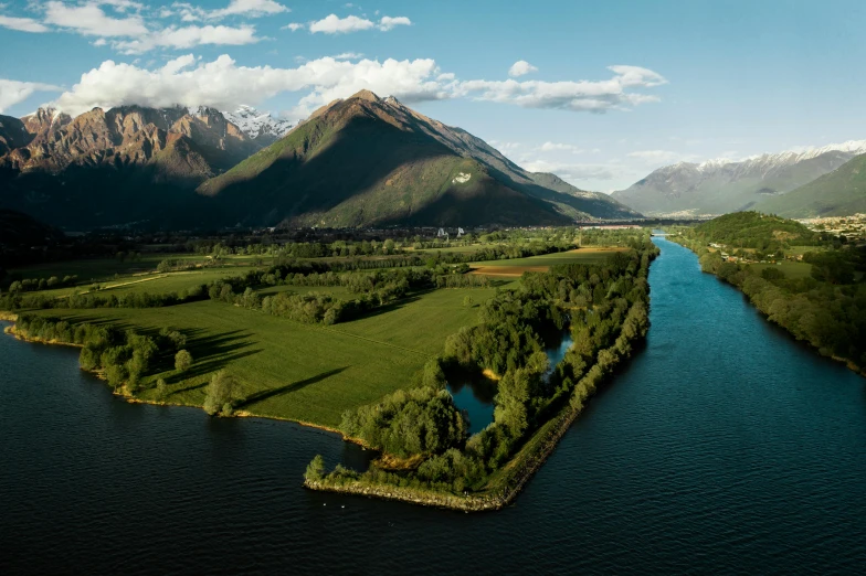 a view of the beautiful countryside and water with mountains in the distance