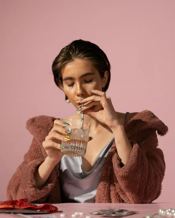 a woman holding up a glass in front of her mouth