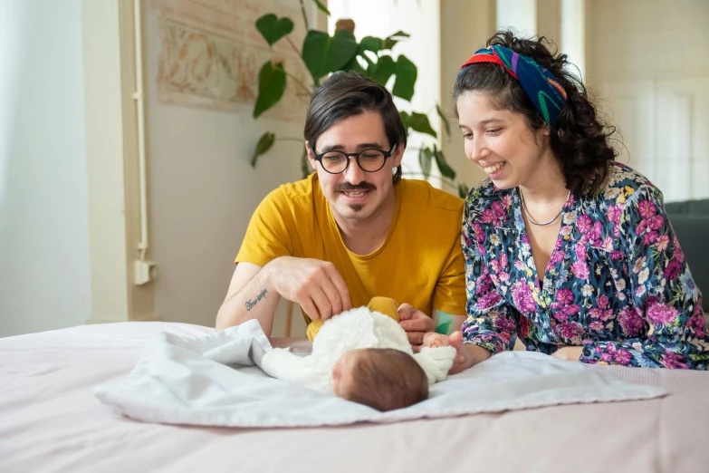 there is a man and a woman that are standing next to a baby