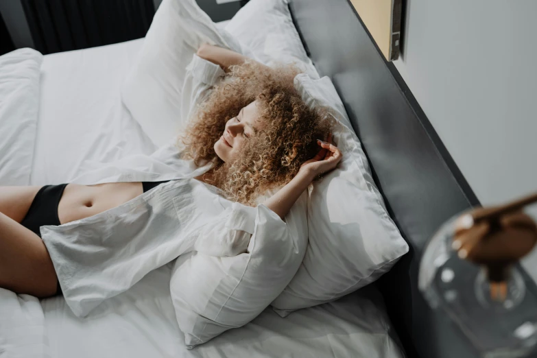 woman laying in bed looking at soing near her