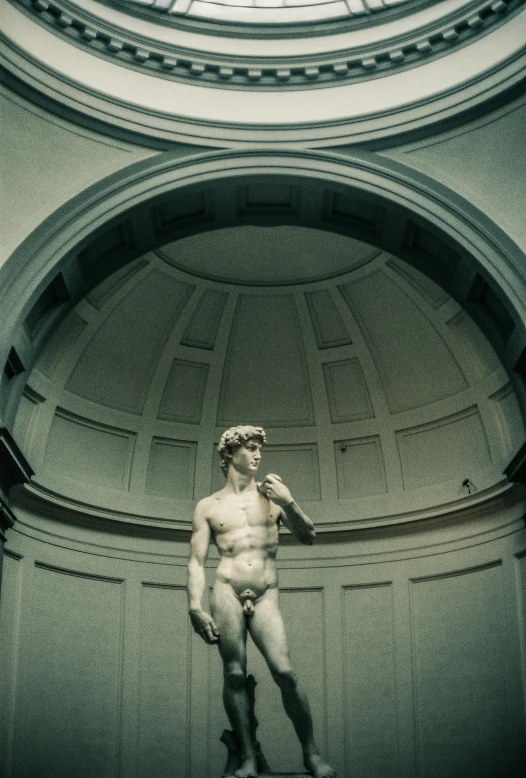 the sculpture of a  man is in a circular room