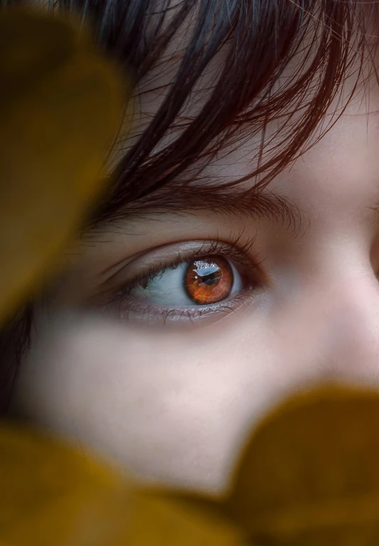 the blue eyes of a woman with green leaves around her head