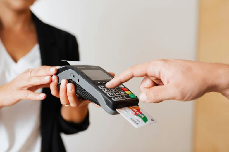 two people exchanging cards and hing a cell phone