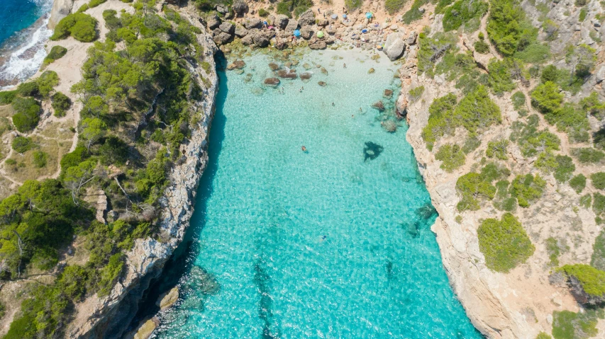 an aerial view of a beautiful pool in the middle of a forested area