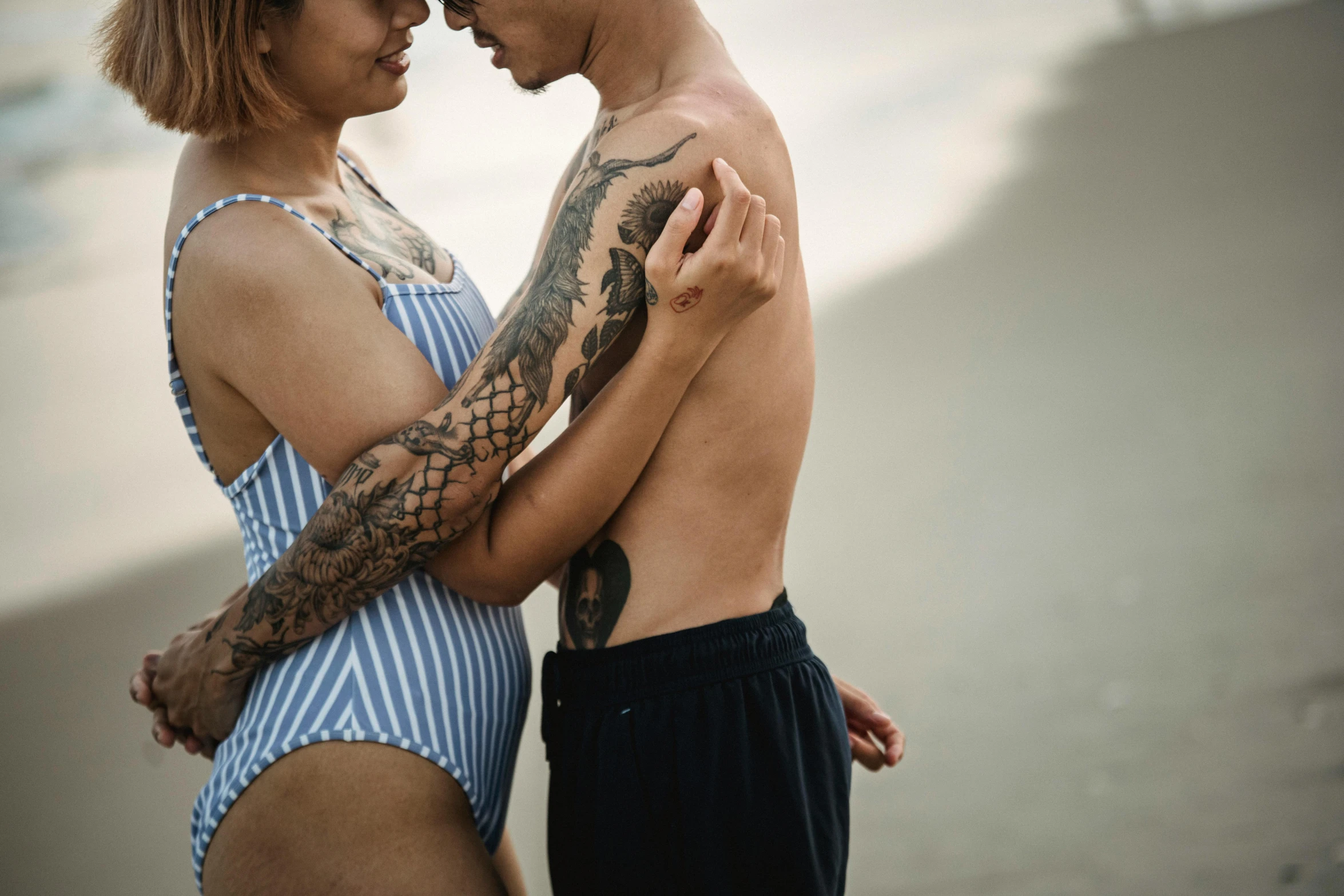 a beautiful woman in a swimsuit hugging a man