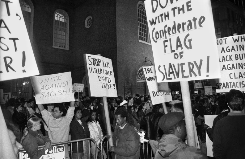 black and white pograph of people holding signs with text