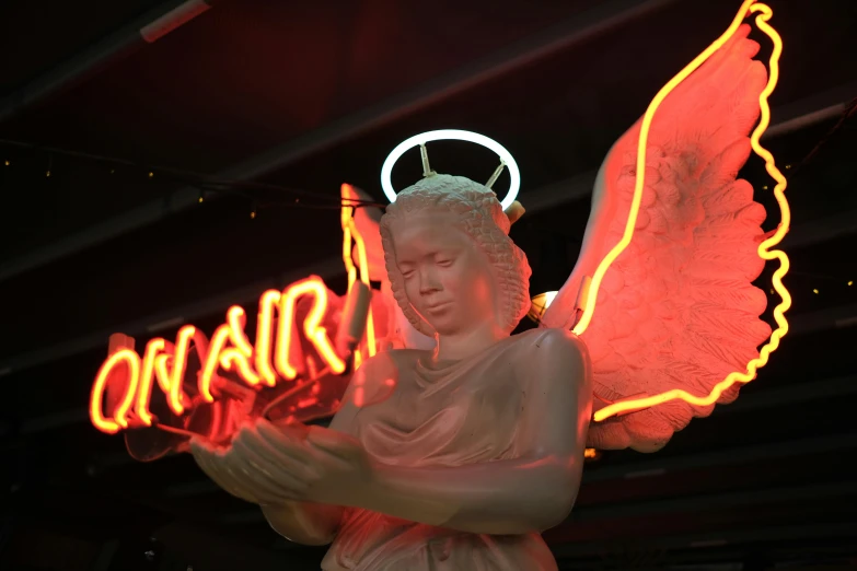 a lit statue is shown next to a neon sign