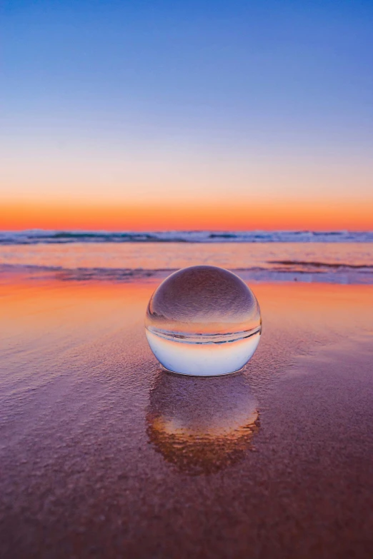 a large ball sitting in the sand on a beach