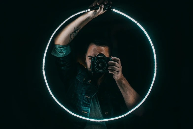 a woman in front of a round mirror taking a picture with a camera