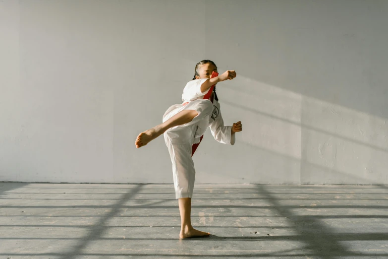 a woman doing a kick kick on a white background