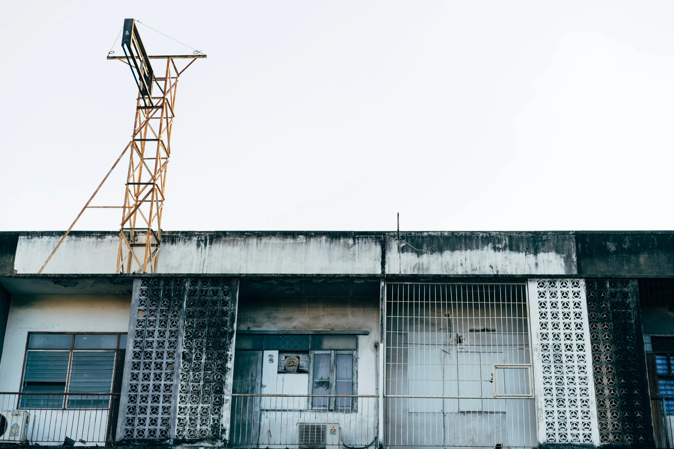 an industrial building with broken glass windows and a crane