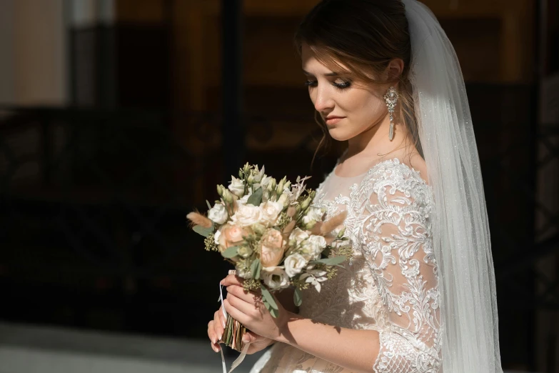 the bride is wearing her wedding dress and bouquet in hand