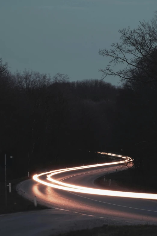 a light streaks down an empty highway at night