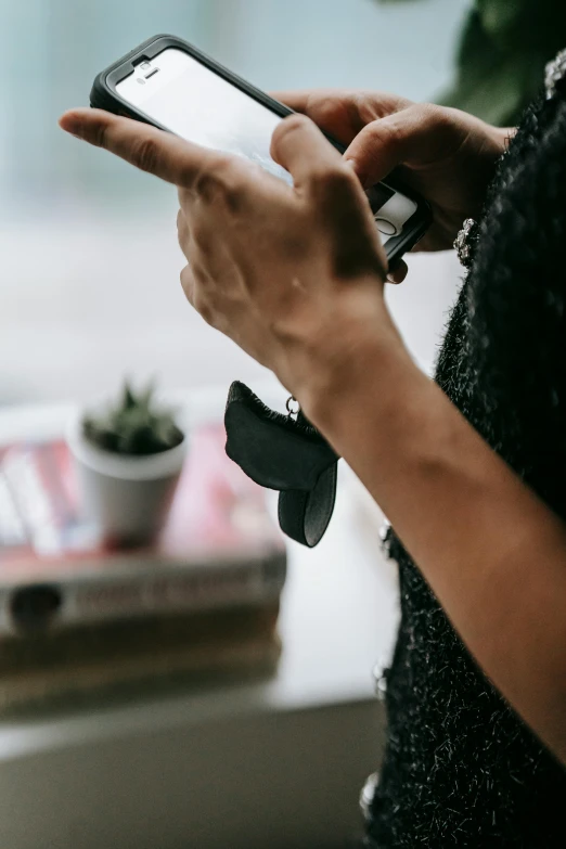 a person holding their phone in one hand and pointing to it