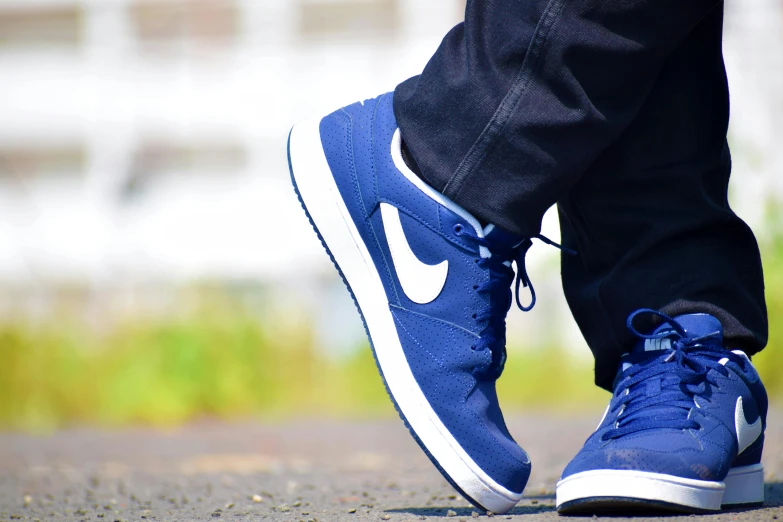 a person's feet with their shoes off and wearing blue shoes