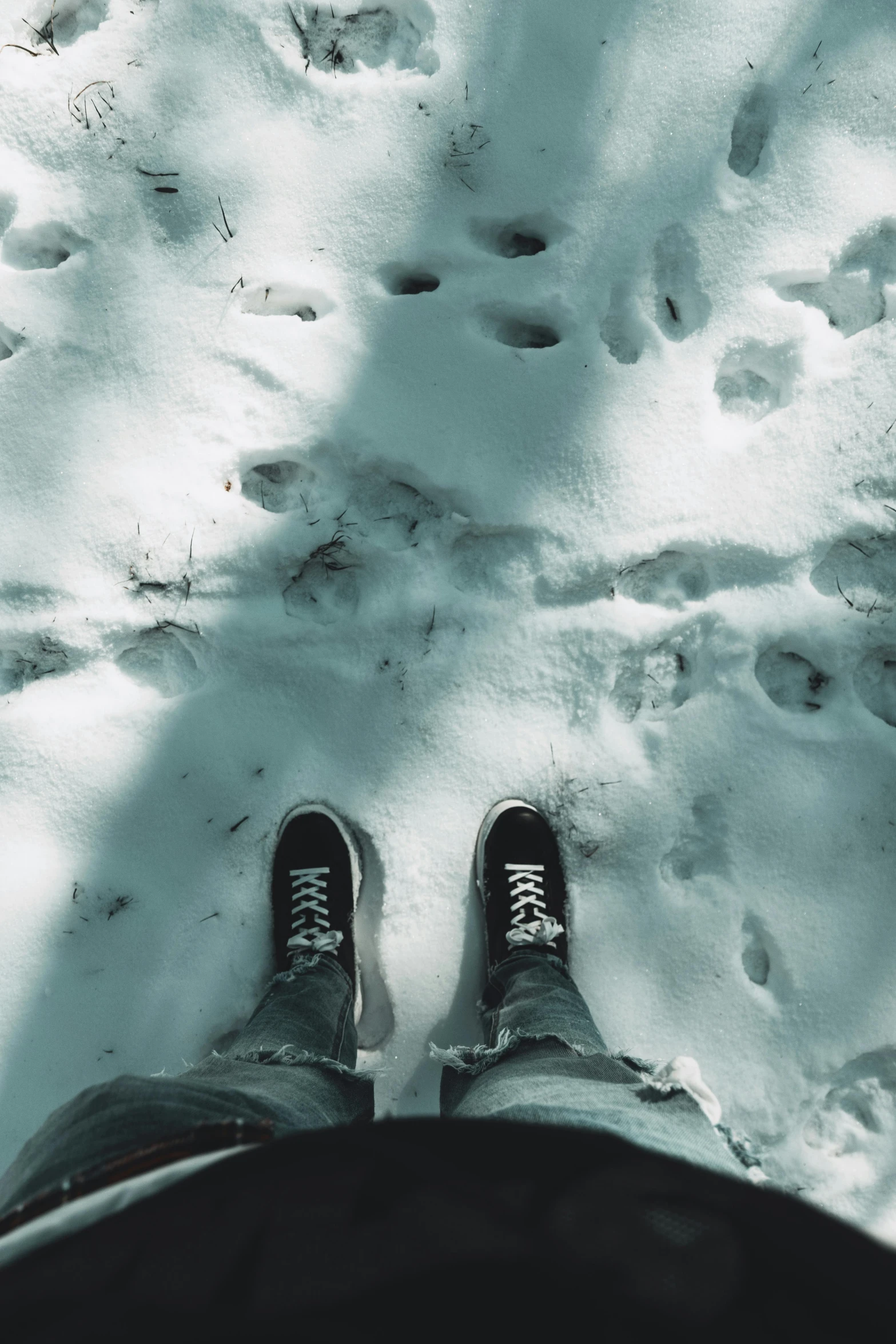 person standing in the snow with their feet up