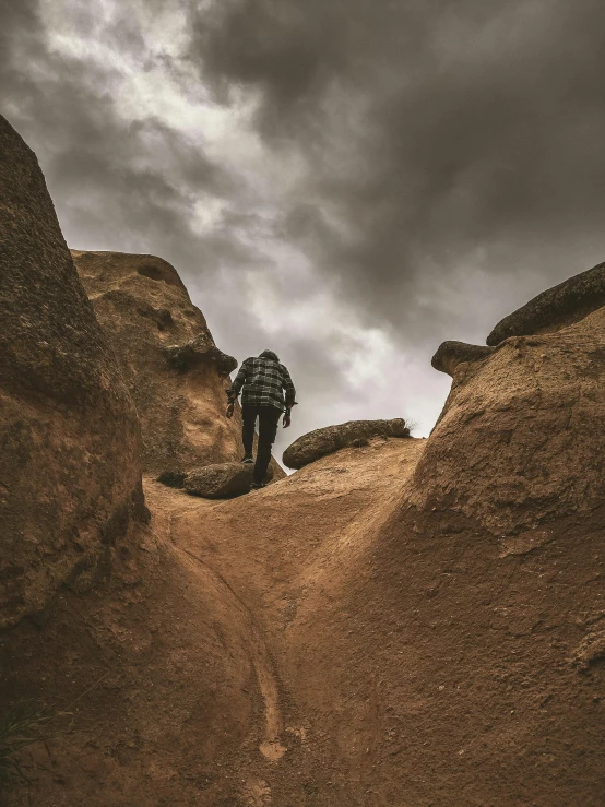 a person walks on the side of a rocky hill