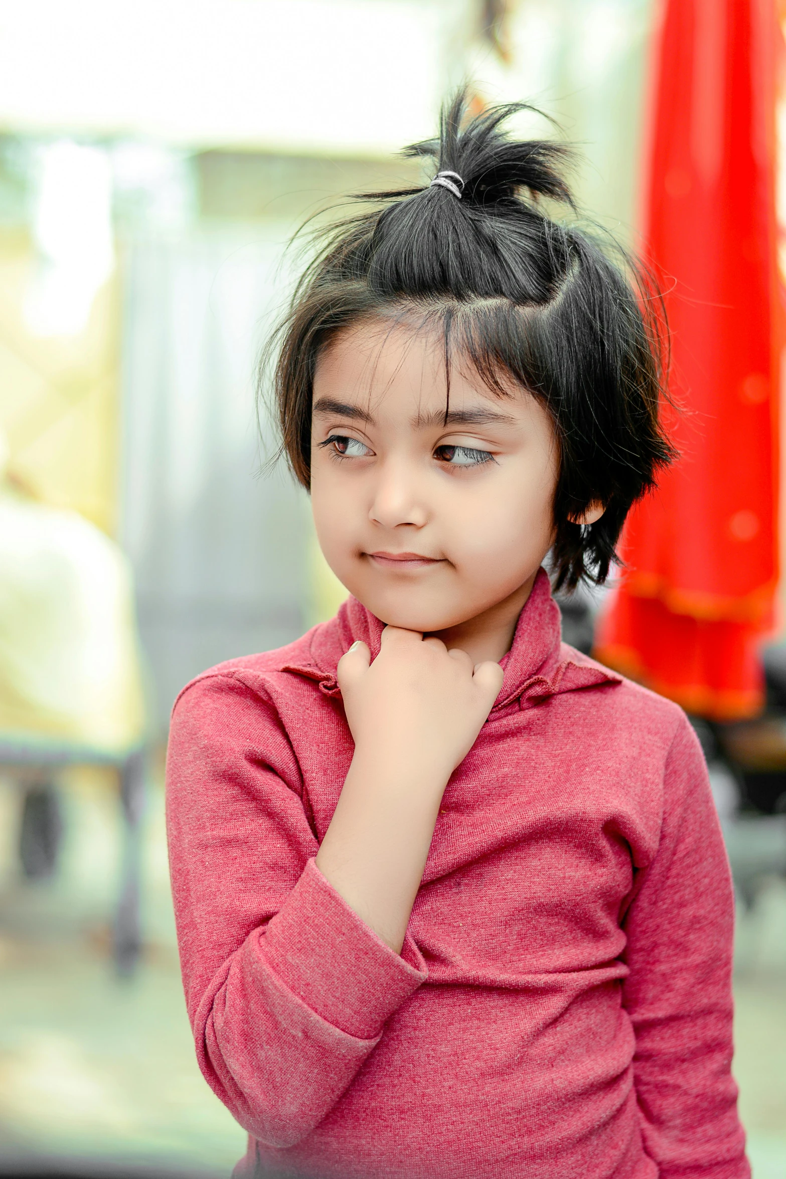 a little girl with a ponytail looking at the camera