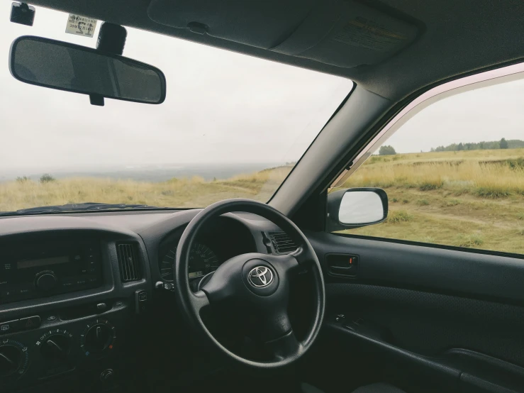 the interior of a vehicle that is driving on a dirt road