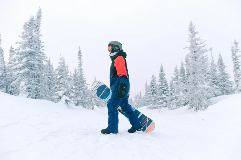 a person walking through the snow with a large board