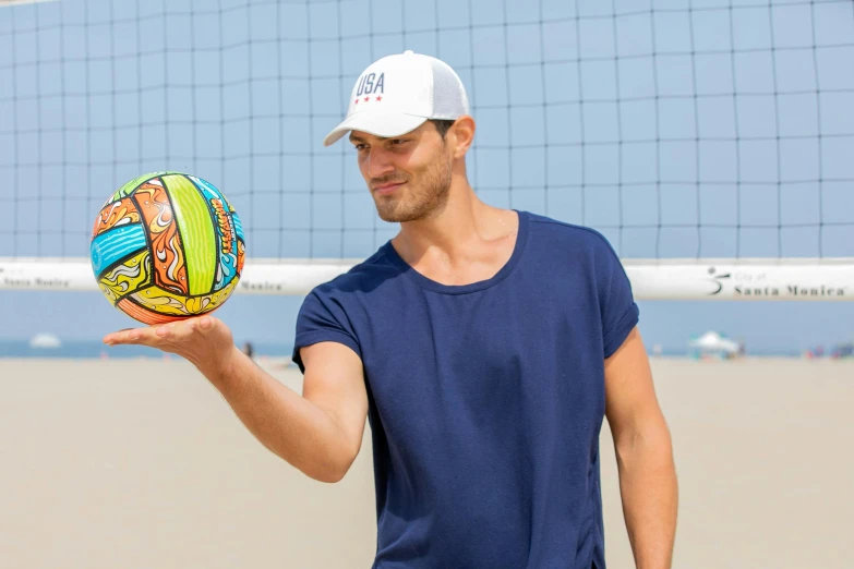 a man holds an inflatable beach volleyball ball