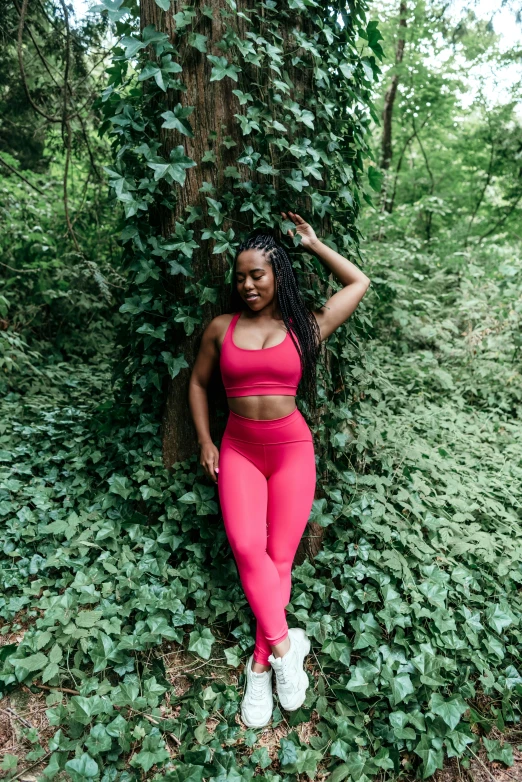 a woman in red posing near a tree