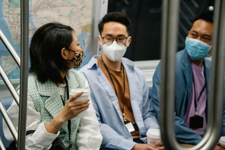 people sitting on a subway looking at their phones