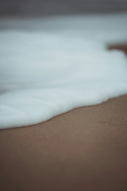 close up of the end of a wave at the edge of the beach