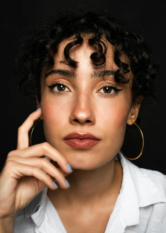 woman with curly hair wearing hoop earrings on her ear