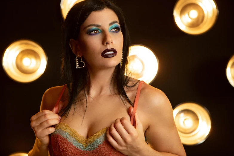 woman with dark makeup wearing gold hoop earrings