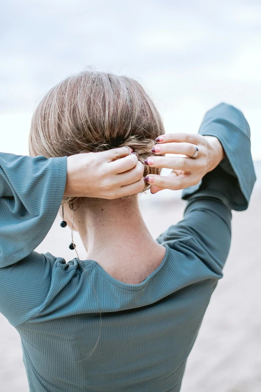 a woman's hands hold her head back with the hair down