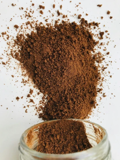 a mason jar full of ground coffee and powdered cocoa