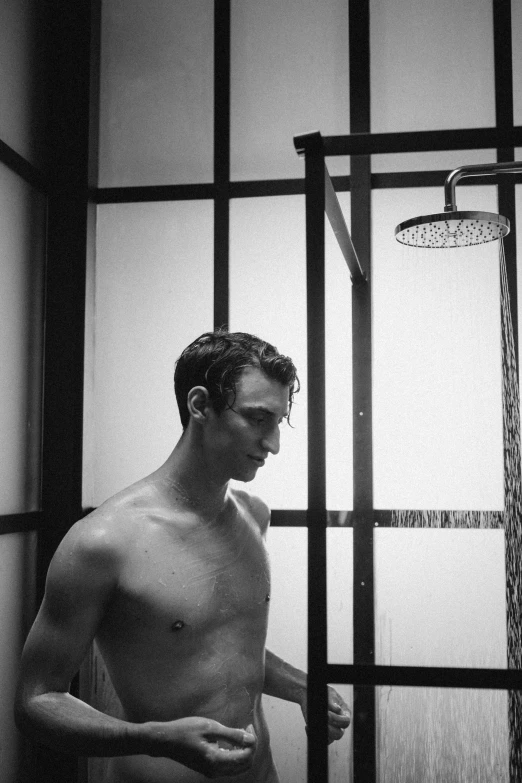 a young man standing in the shower in his bathroom