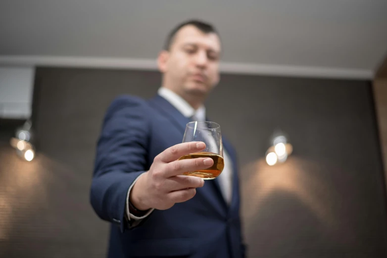 man in business suit holding a glass of whisky