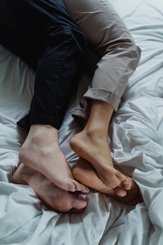 person laying in bed with his bare feet above him