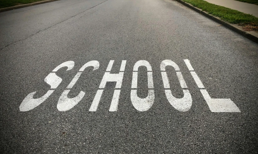 a school painted on the street by a stop sign